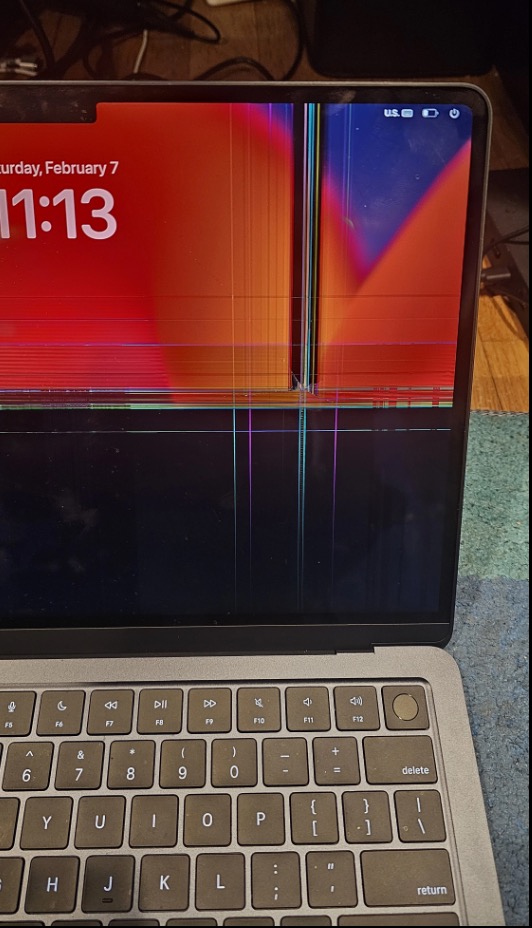 MacBook with cracked screen before repair — damaged display showing discoloration and cracks across the panel